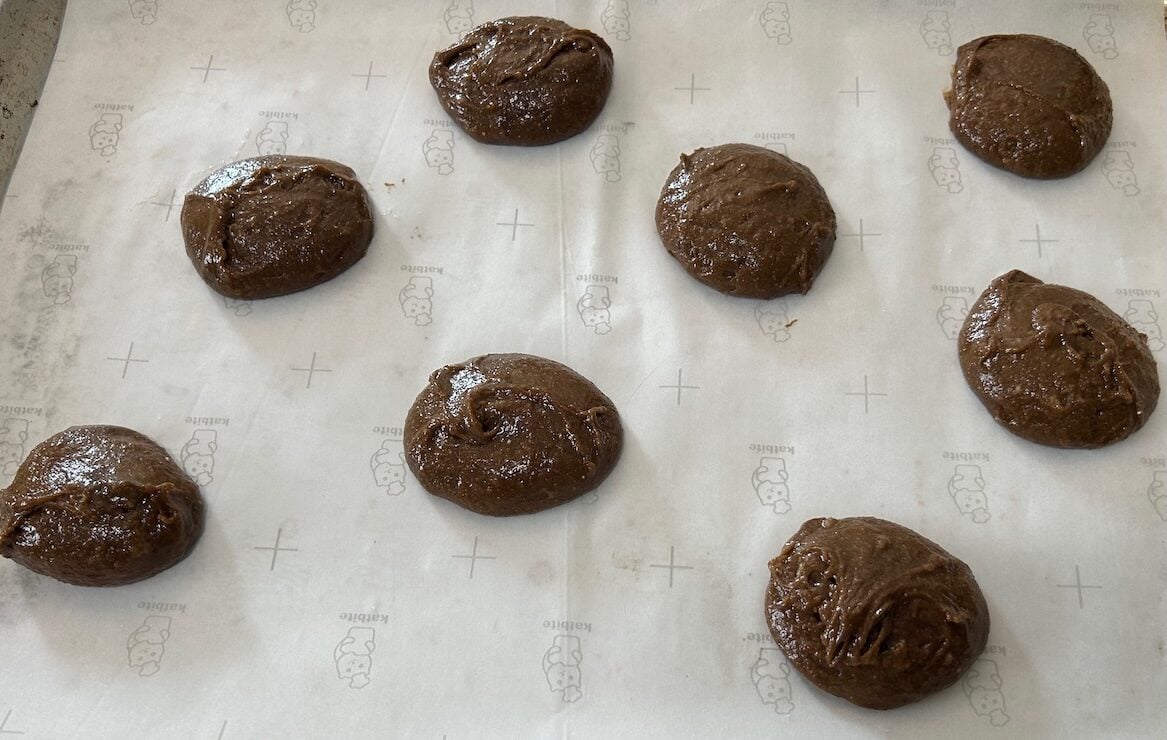 gingerbread cookie dough scooped onto parchment lined baking sheet