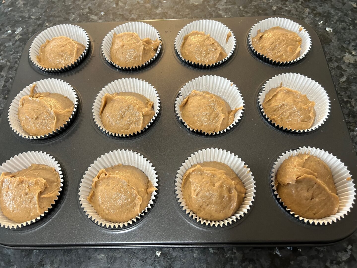 muffin tin with batter scooped into the liners