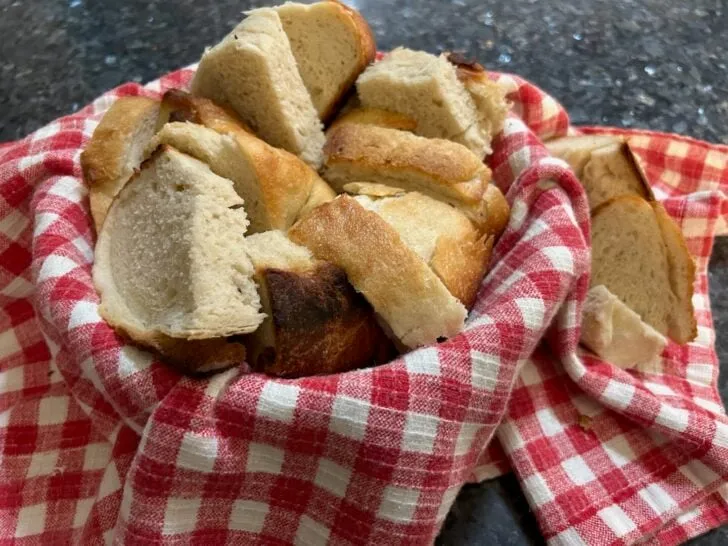 slices of sourdough in basket with towel
