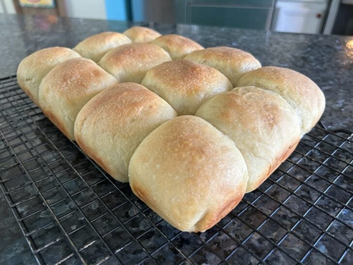 a dozen dinner rolls on wire cooling rack