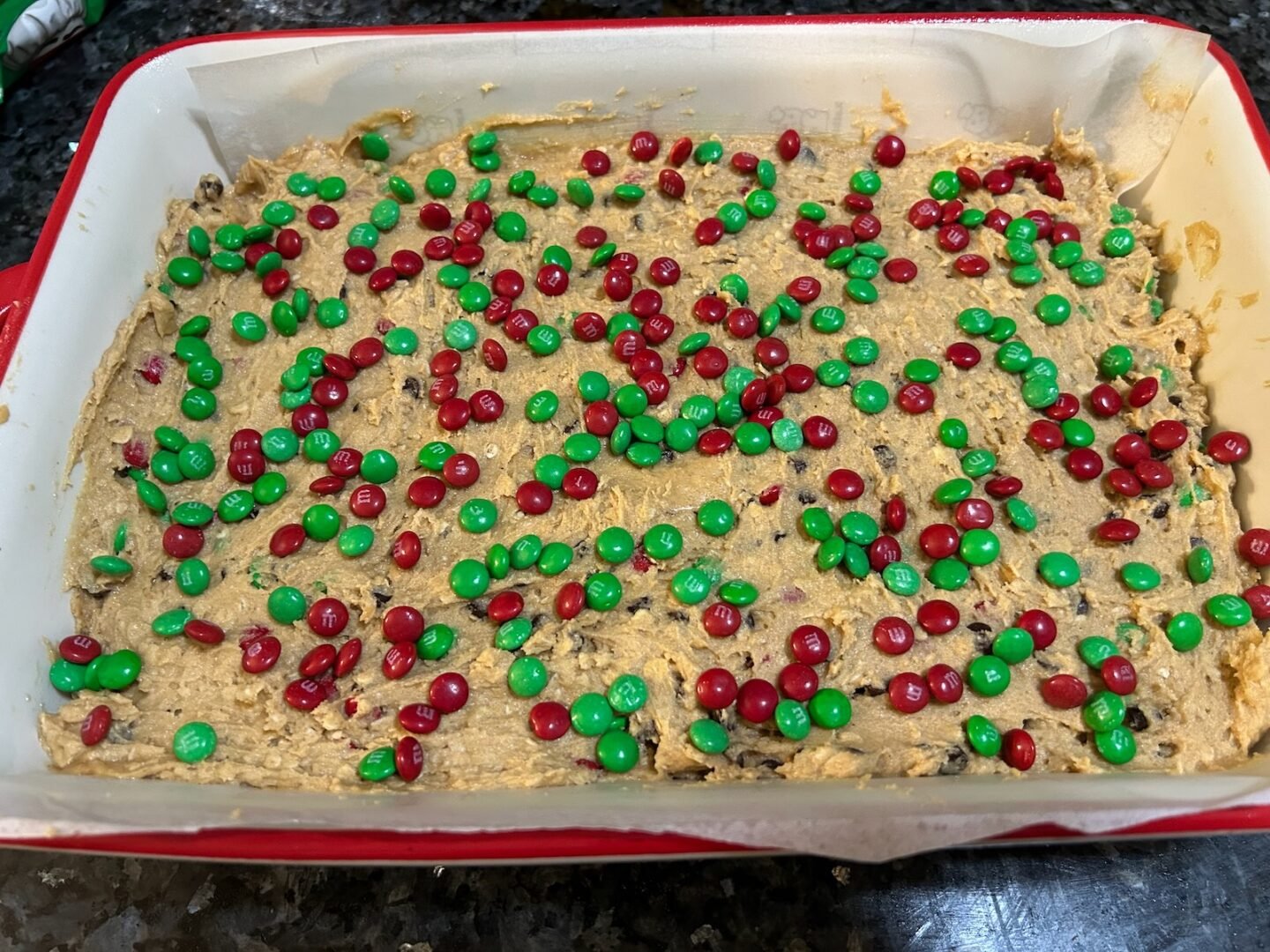 cookie dough in casserole dish with M&Ms on top