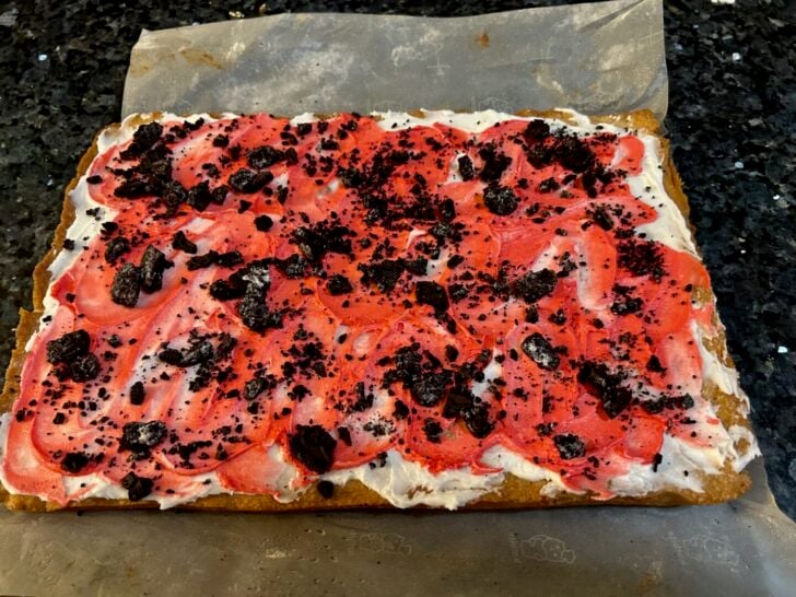 Peppermint Bark Cookie Bars with frosting and crushed Oreos
