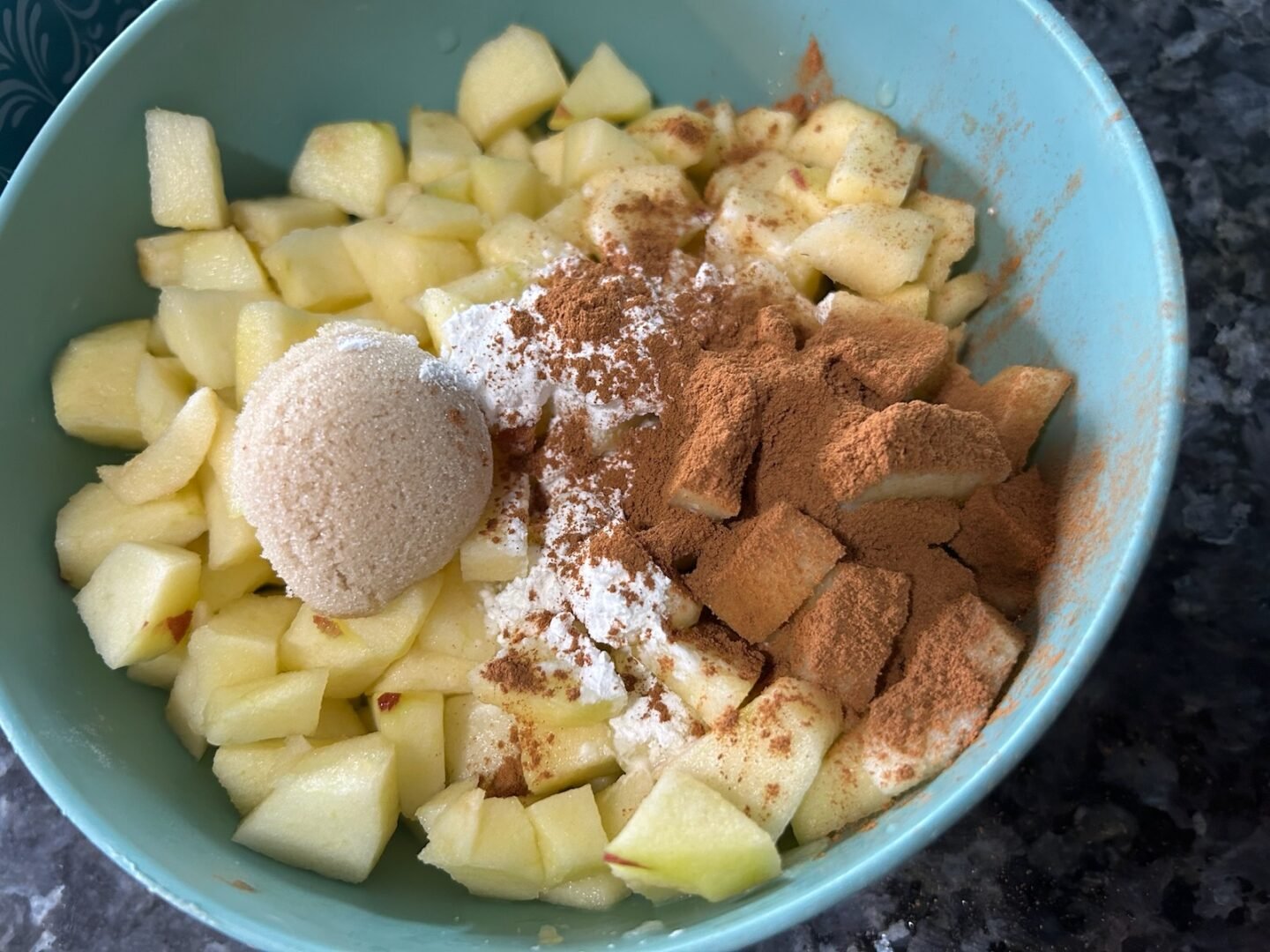 diced apples in bowl with cinnamon, brown sugar, and cornstarch