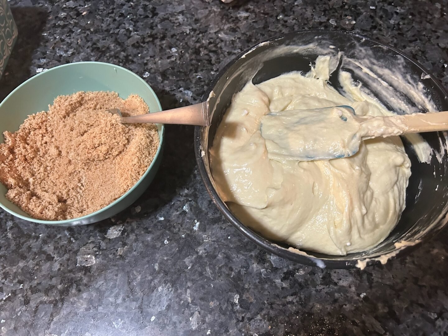 bowl of cake batter next to a bowl of brown sugar and cinnamon