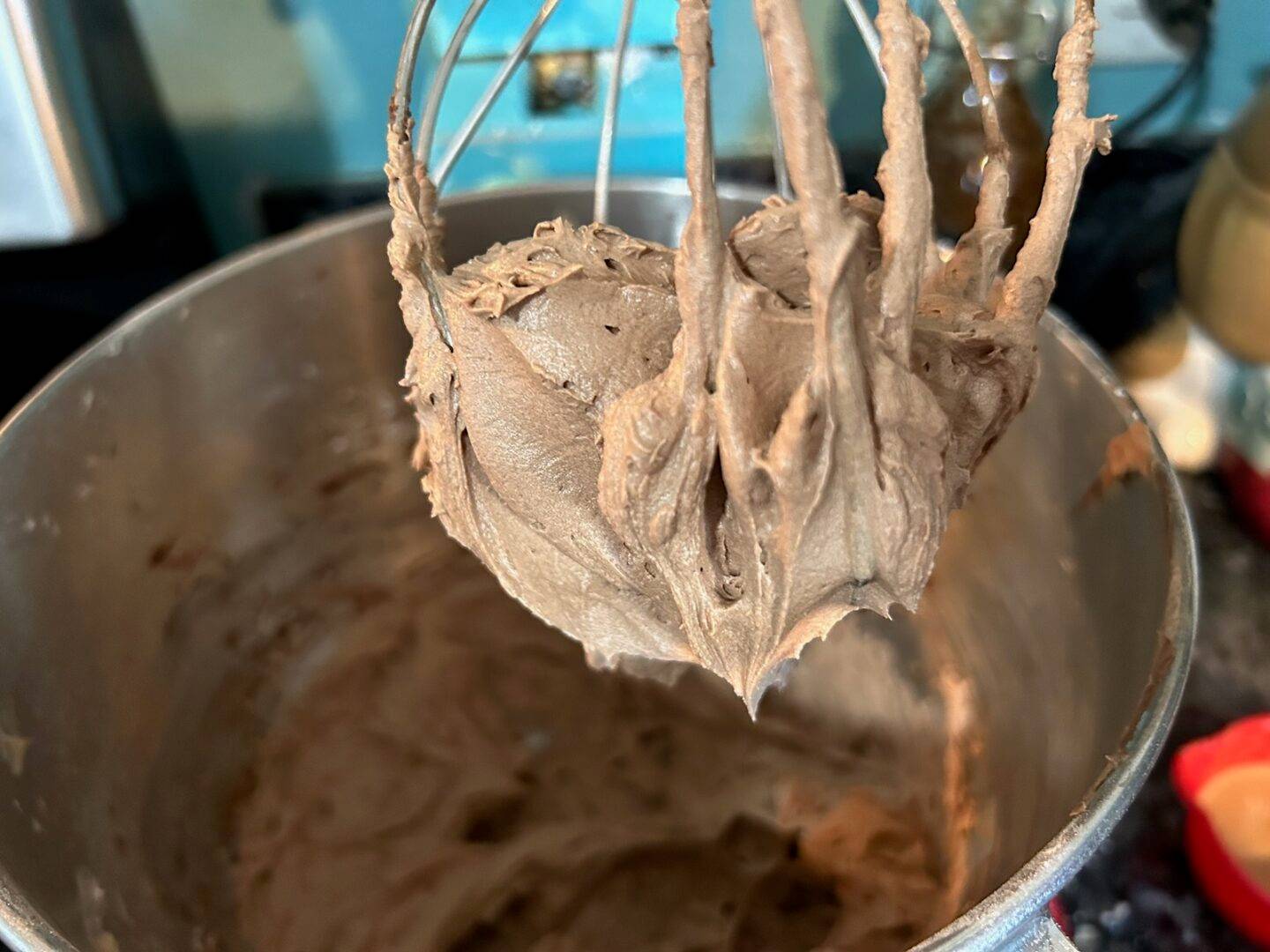 Chocolate frosting in bowl with whisk