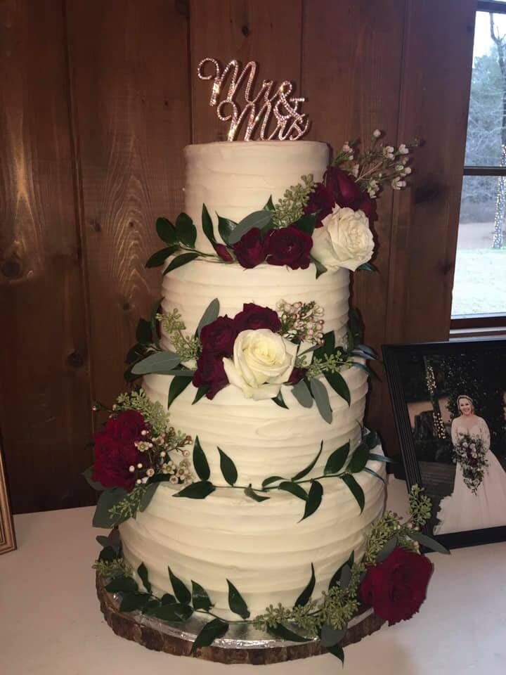 four tiered southern wedding cake with roses and greenery