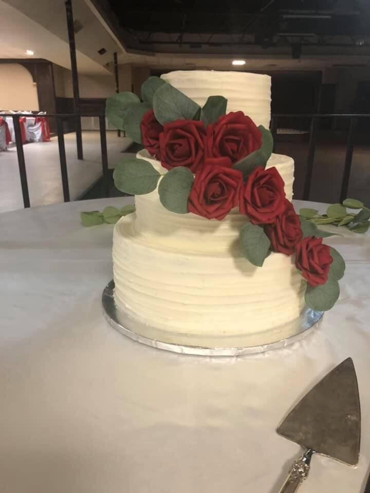 3-tiered white wedding cake with deep red roses