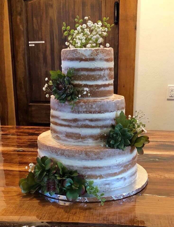naked wedding cake with greenery