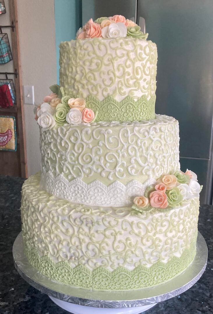 soft green themed wedding cake with scrolling and flowers