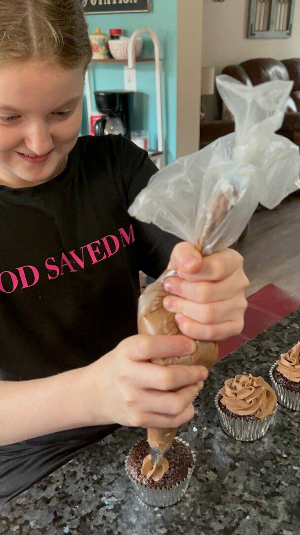 Piping cupcakes with chocolate frosting