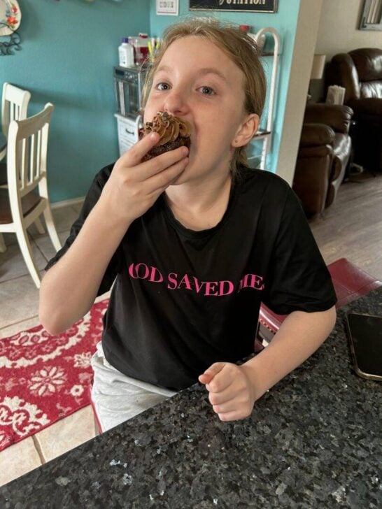 Pre-teen girl eating chocolate cupcake