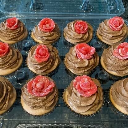 cupcakes with chocolate frosting and candy rose in red
