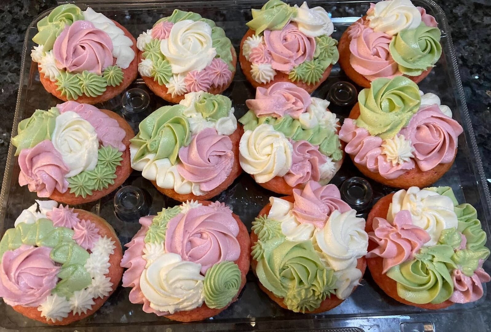 cupcakes designed with swirls and rosettes in pink, white, and soft green