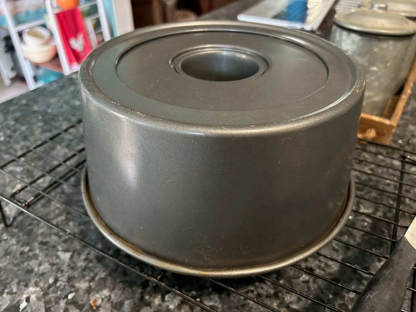 angel food cake tube pan flipped upside-down on wire rack to cool