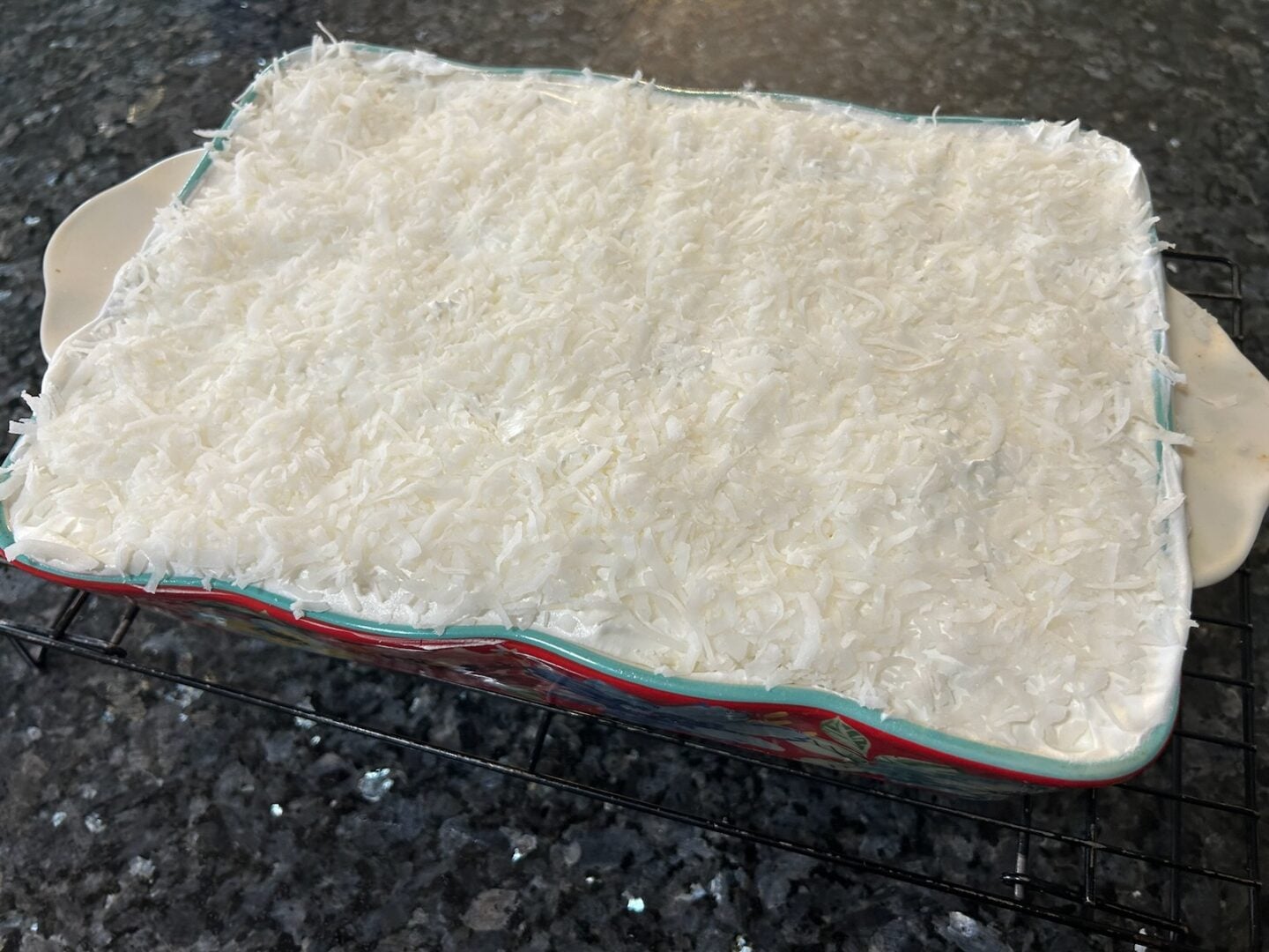 layer of coconut spread over whipped cream cake