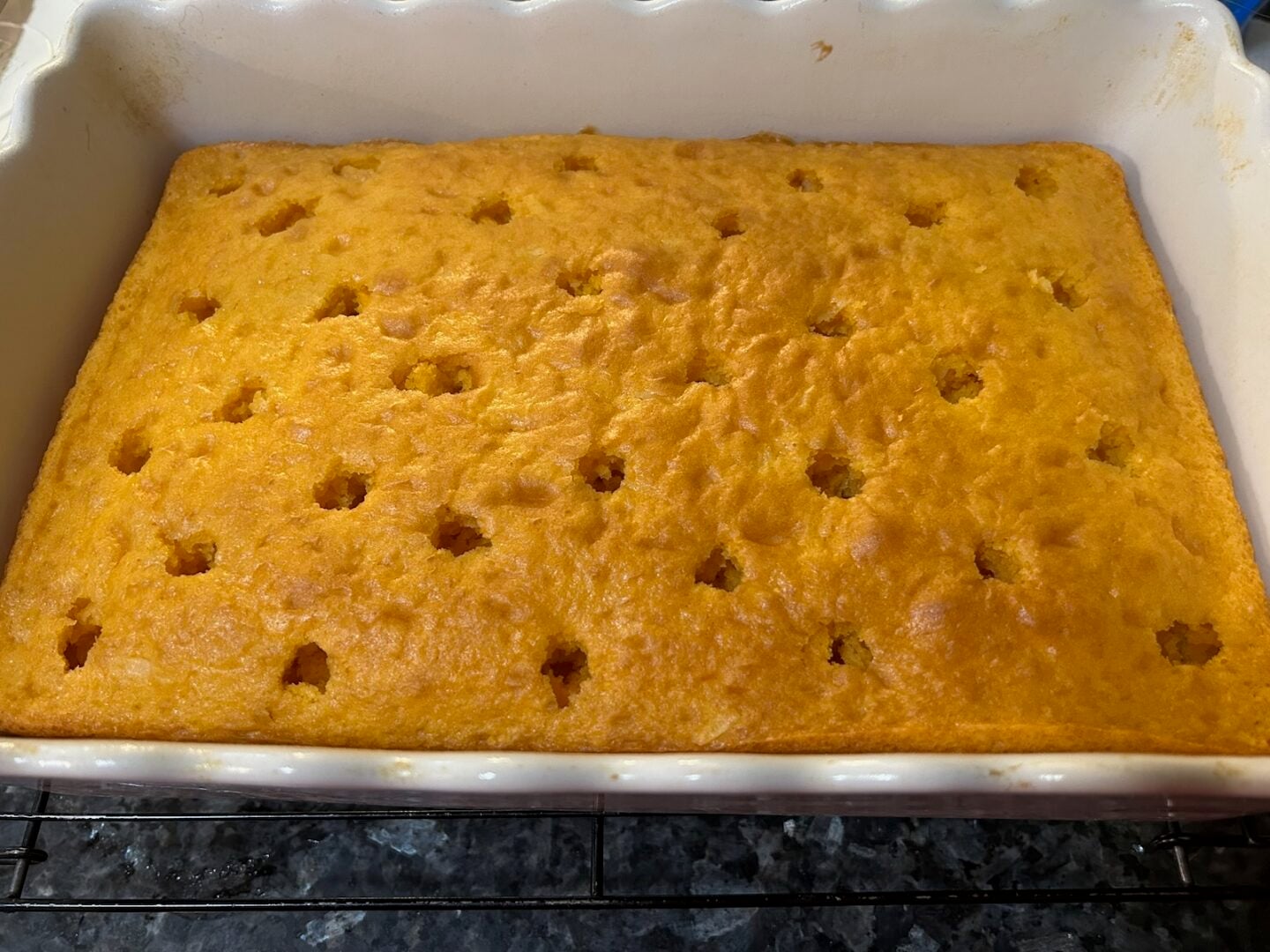 baked orange cake with holes poked in it