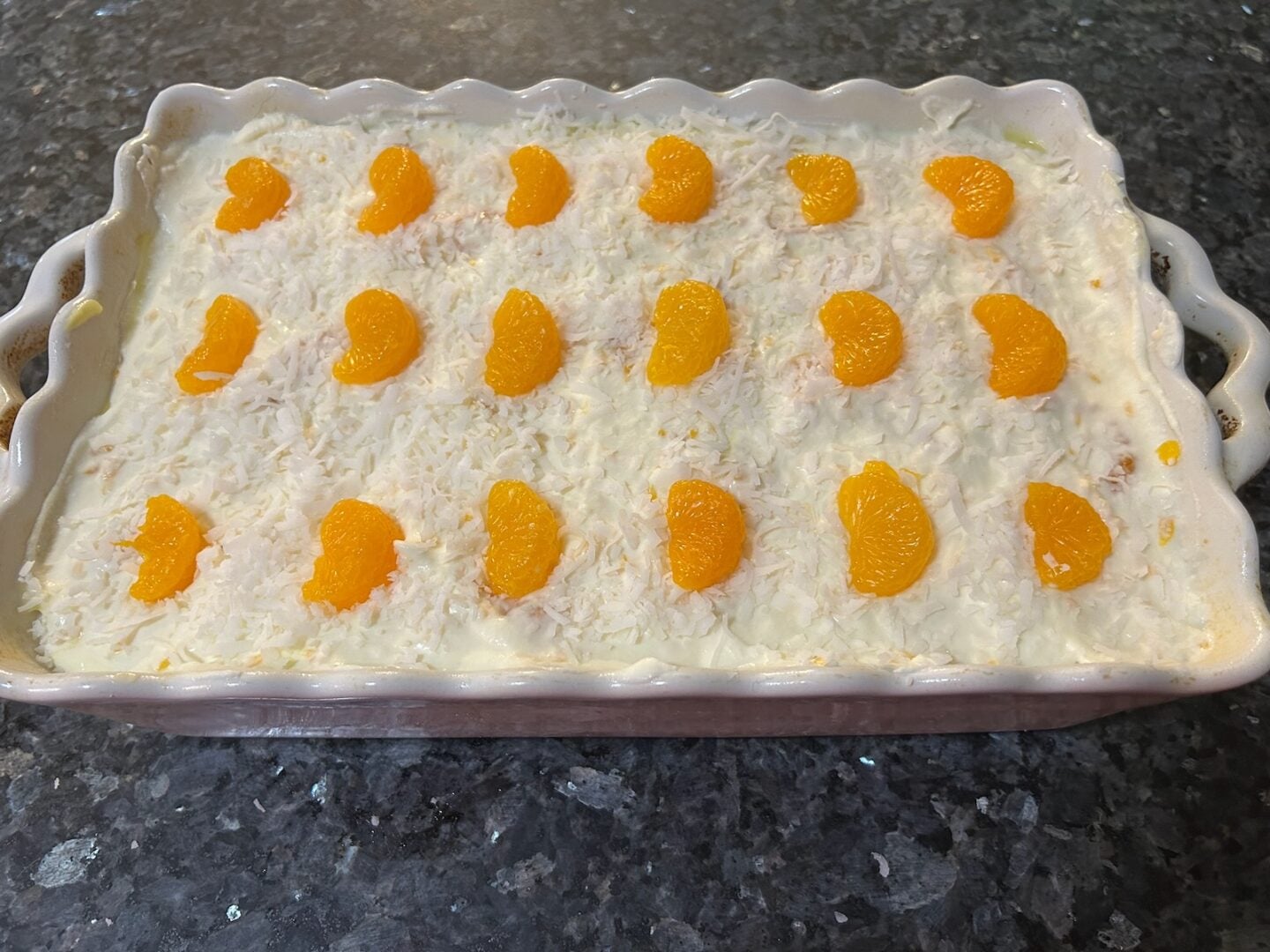 Mandarin orange poke cake, decorated with mandarin oranges