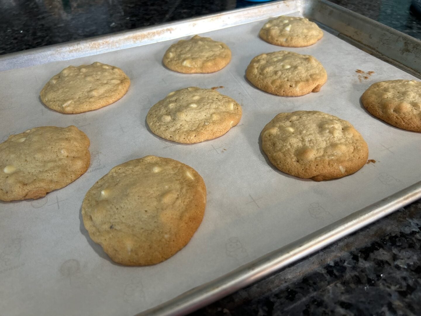 fresh baked white chocolate macadamia nut cookies straight from the oven on baking sheet