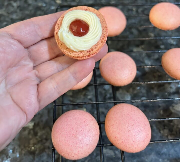 pink macarons with buttercream ring and strawberry jam filling