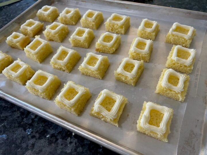 lemon cake cute into squares with buttercream piped on top around edges