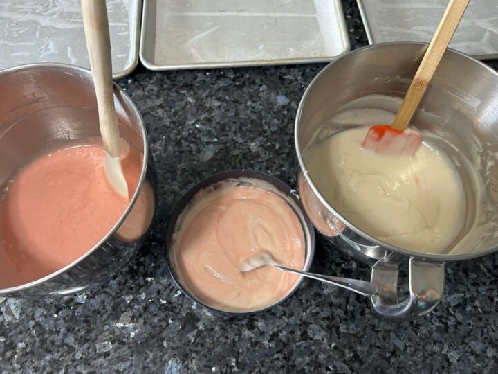 three bowls of cake batter: pink, pale pink, white