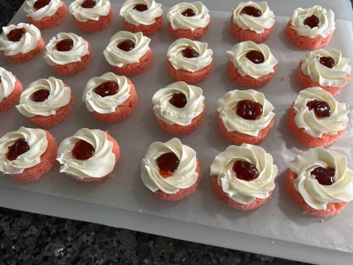 ring of buttercream frosting on bottom round cake and filled with strawberry preserves