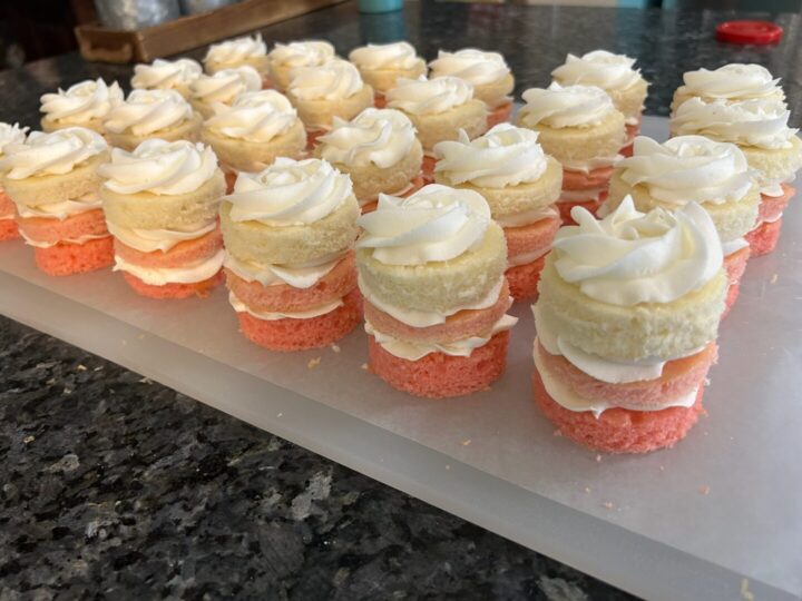 white cake rounds added to mini layer cakes, frosted in white buttercream rosette