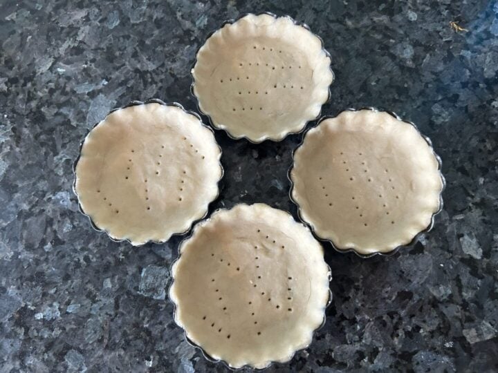 dough in tart pans pricked