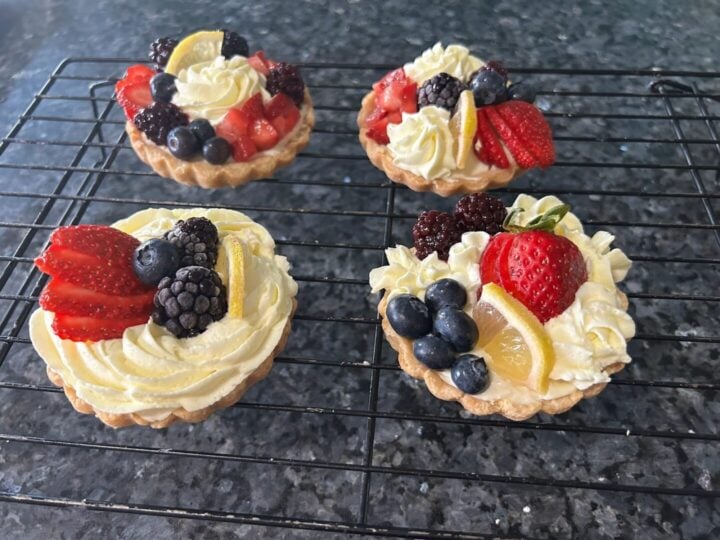four berry tarts on cooling rack