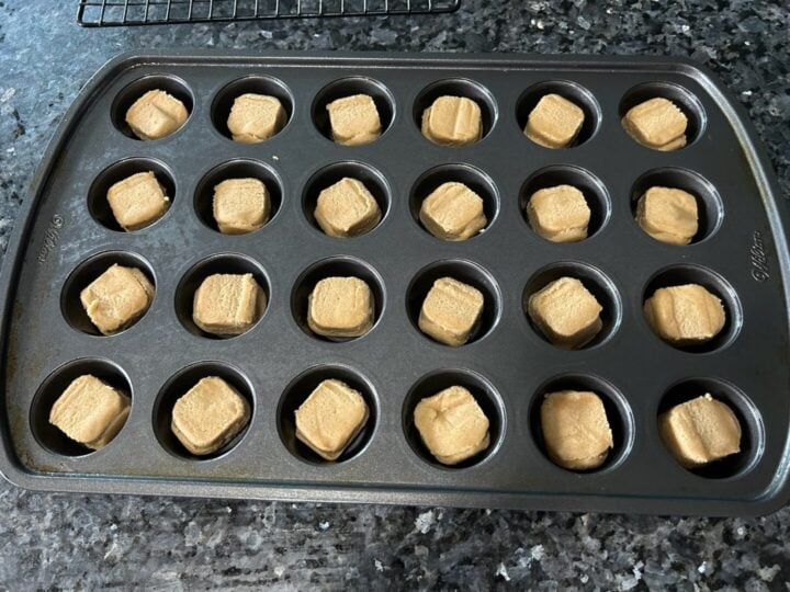 peanut butter cookie dough pieces in muffin tin