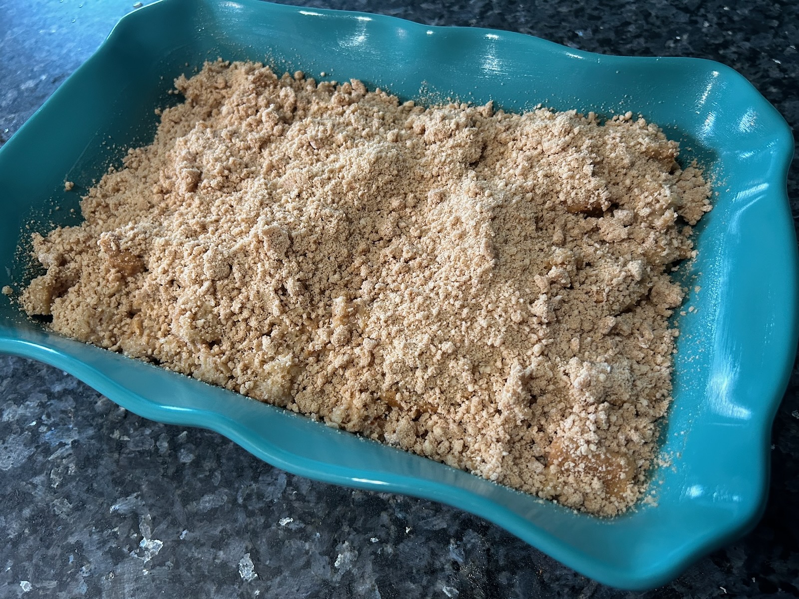 streusel topped bread pudding in casserole dish, ready to be baked