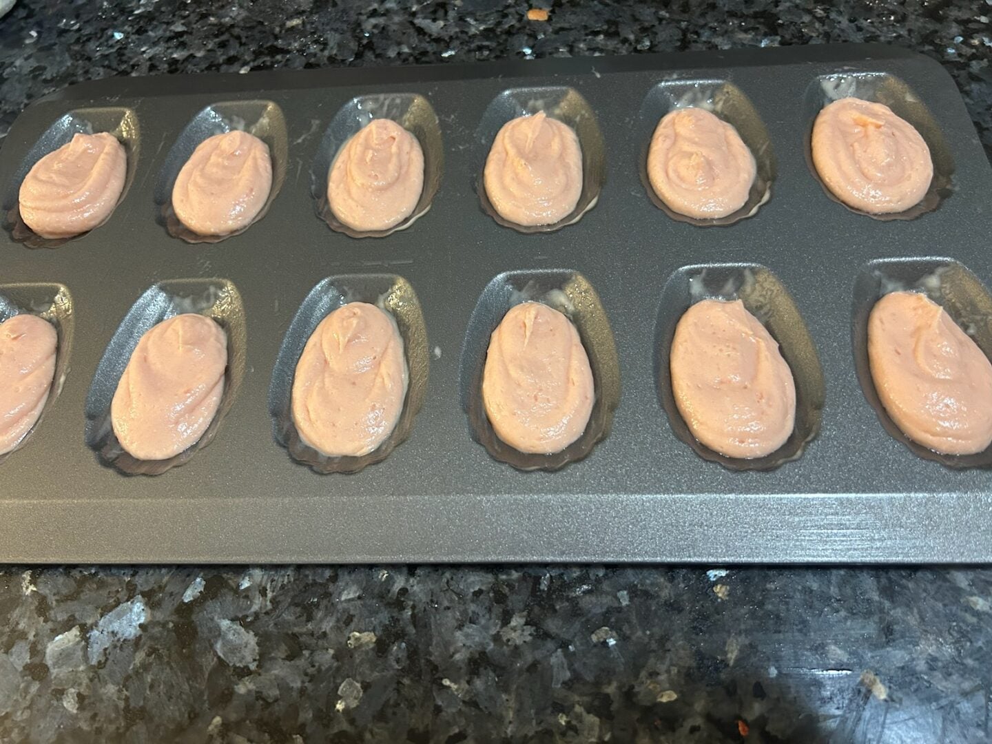 Madeleine batter in pan, ready to bake