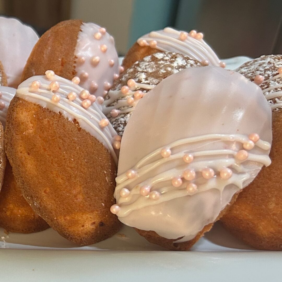 beautifully decorated cake mix madeleines in shades of pink and white on trays