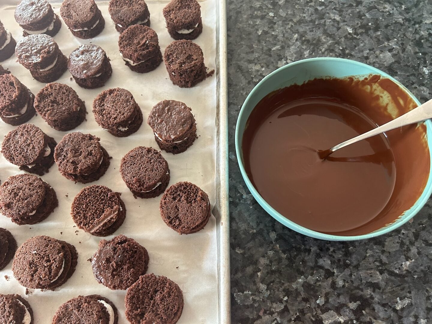 cake circles on tray next to a bowl of melted chocolate