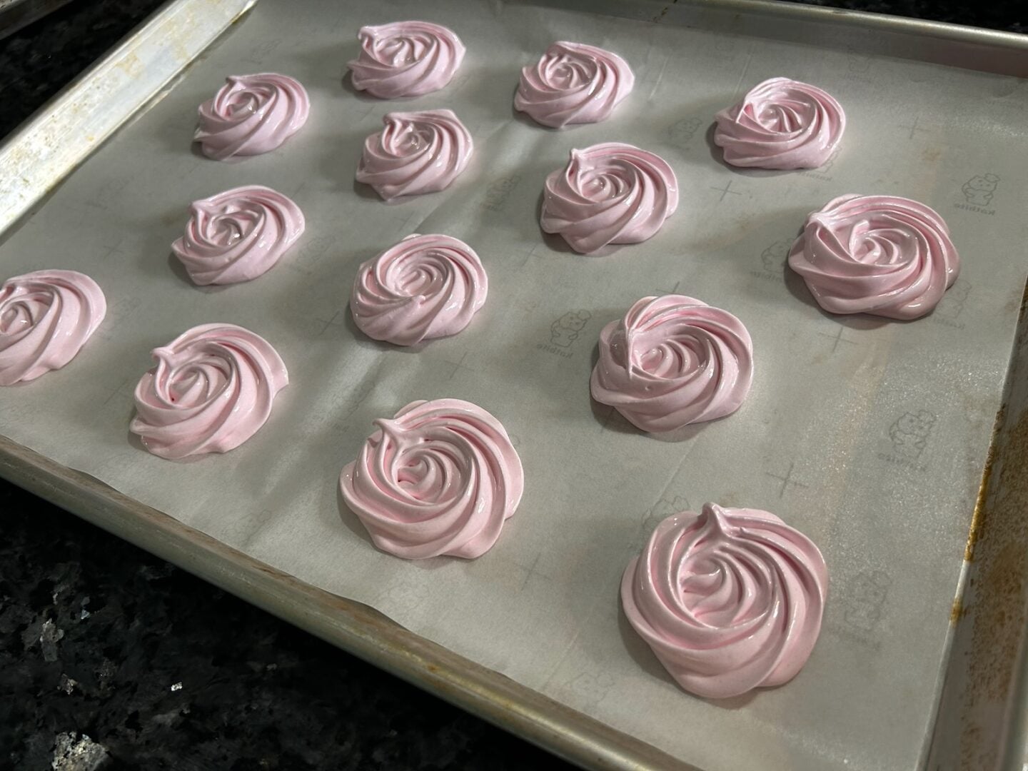 meringue rosettes piped onto baking sheet