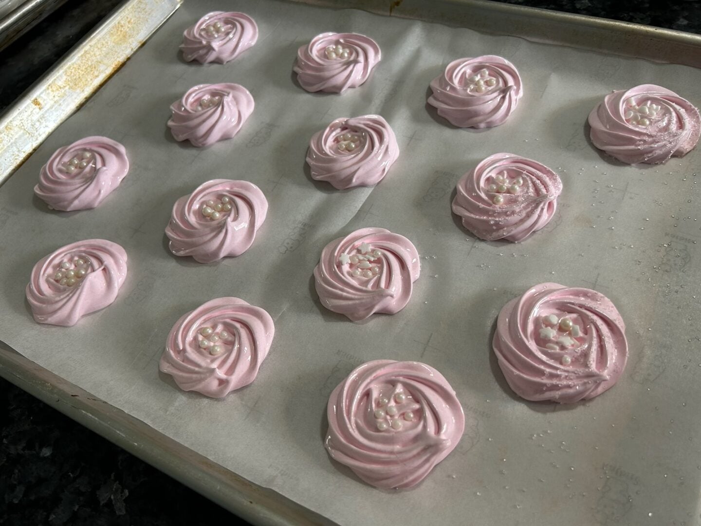 meringue rosettes piped onto baking sheet
