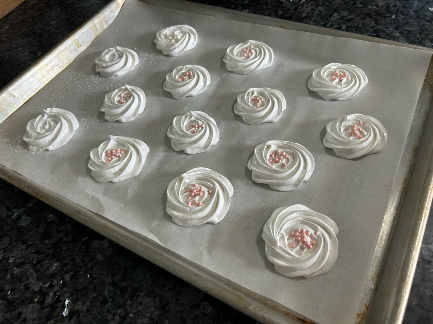 meringue rosettes piped onto baking sheet