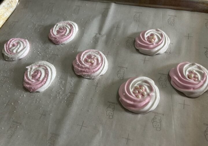 meringue rosettes piped onto baking sheet