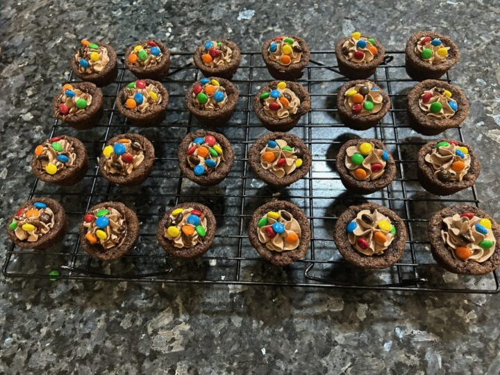 chocolate cookie cups filled with chocolate marshmallow fluff frosting and topped with mini M&Ms