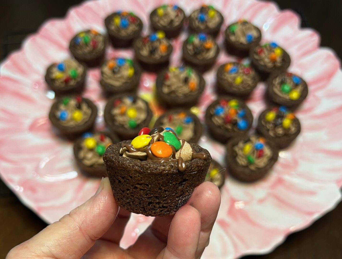 chocolate cookie cups filled with chocolate marshmallow fluff frosting and topped with mini M&Ms