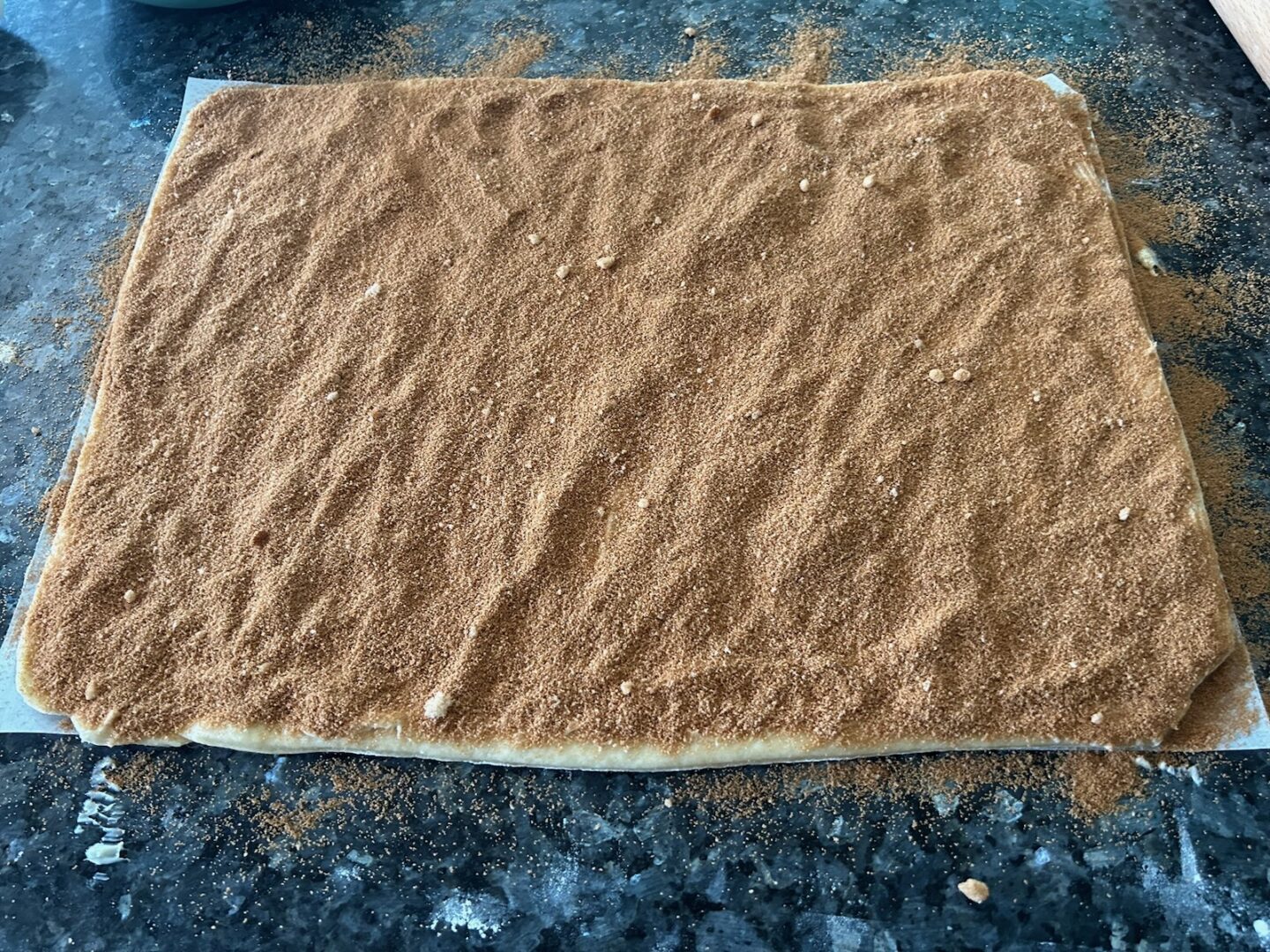 cinnamon roll dough with cinnamon and brown sugar on top