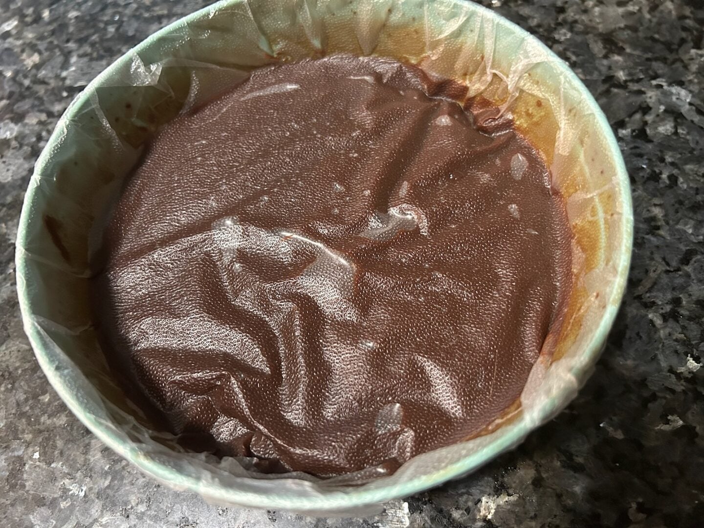 chocolate ganache in bowl covered with plastic wrap