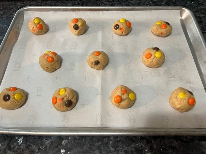 Reese's pieces cookie dough balls on baking sheet