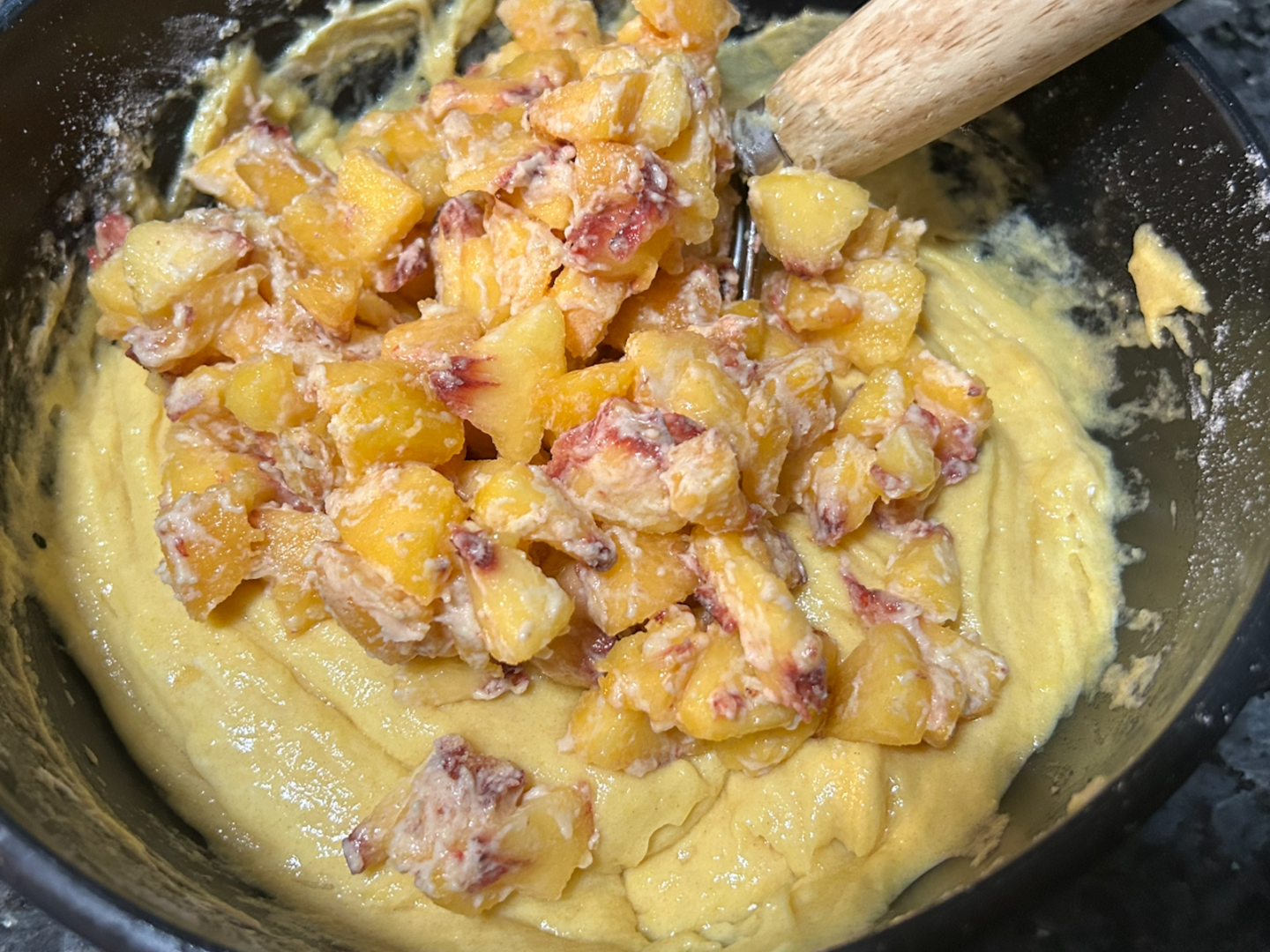 Easy Peach Coffee Cake batter in bowl with peaches added
