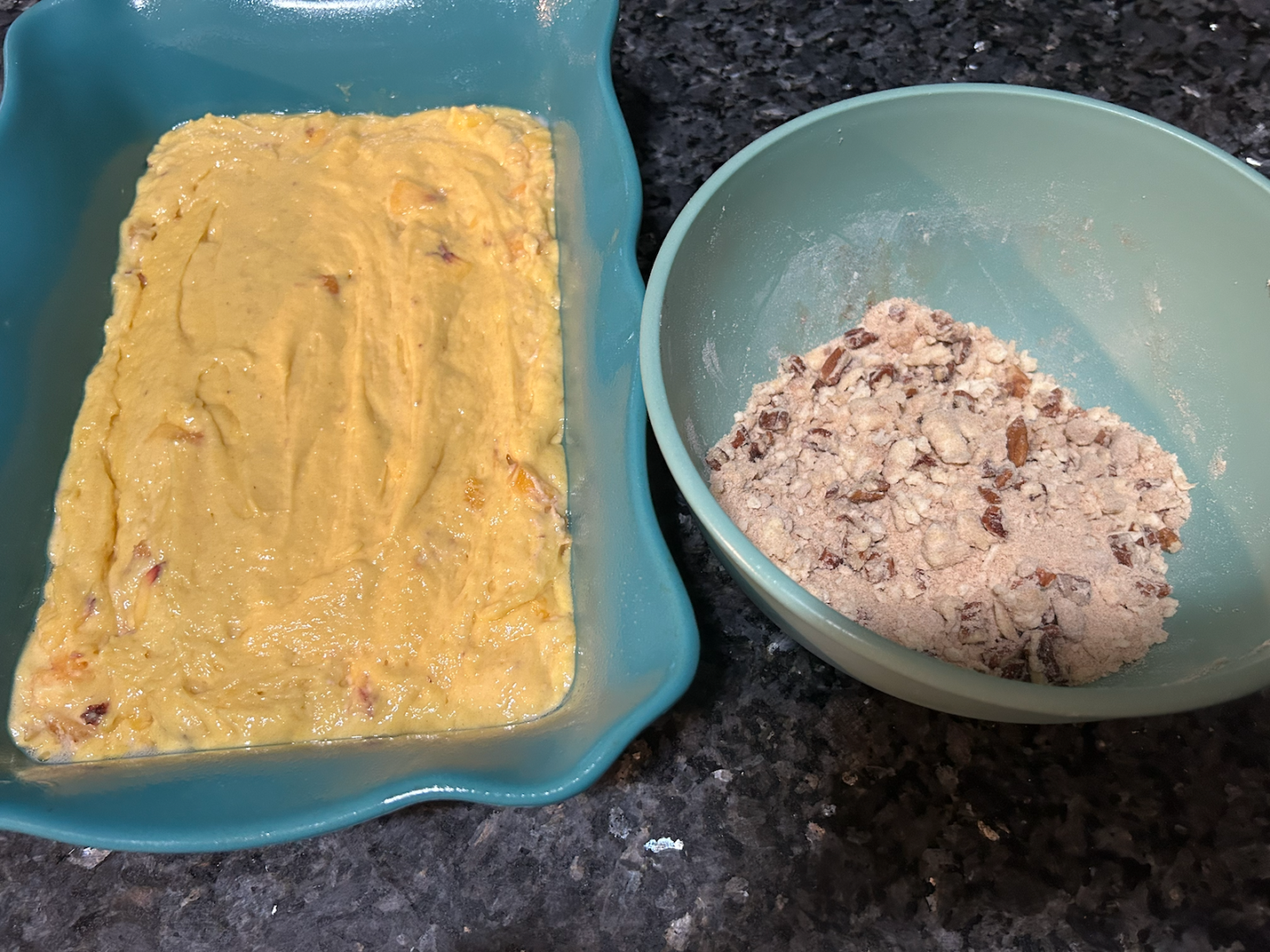 Easy Peach Coffee Cake batter in casserole dish next to bowl of streusel topping