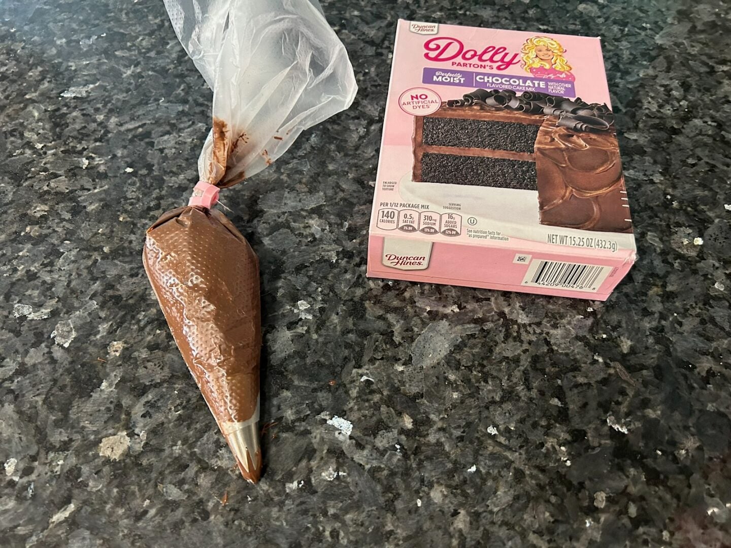 nutella in piping bag next to box of Dolly Parton chocolate cake