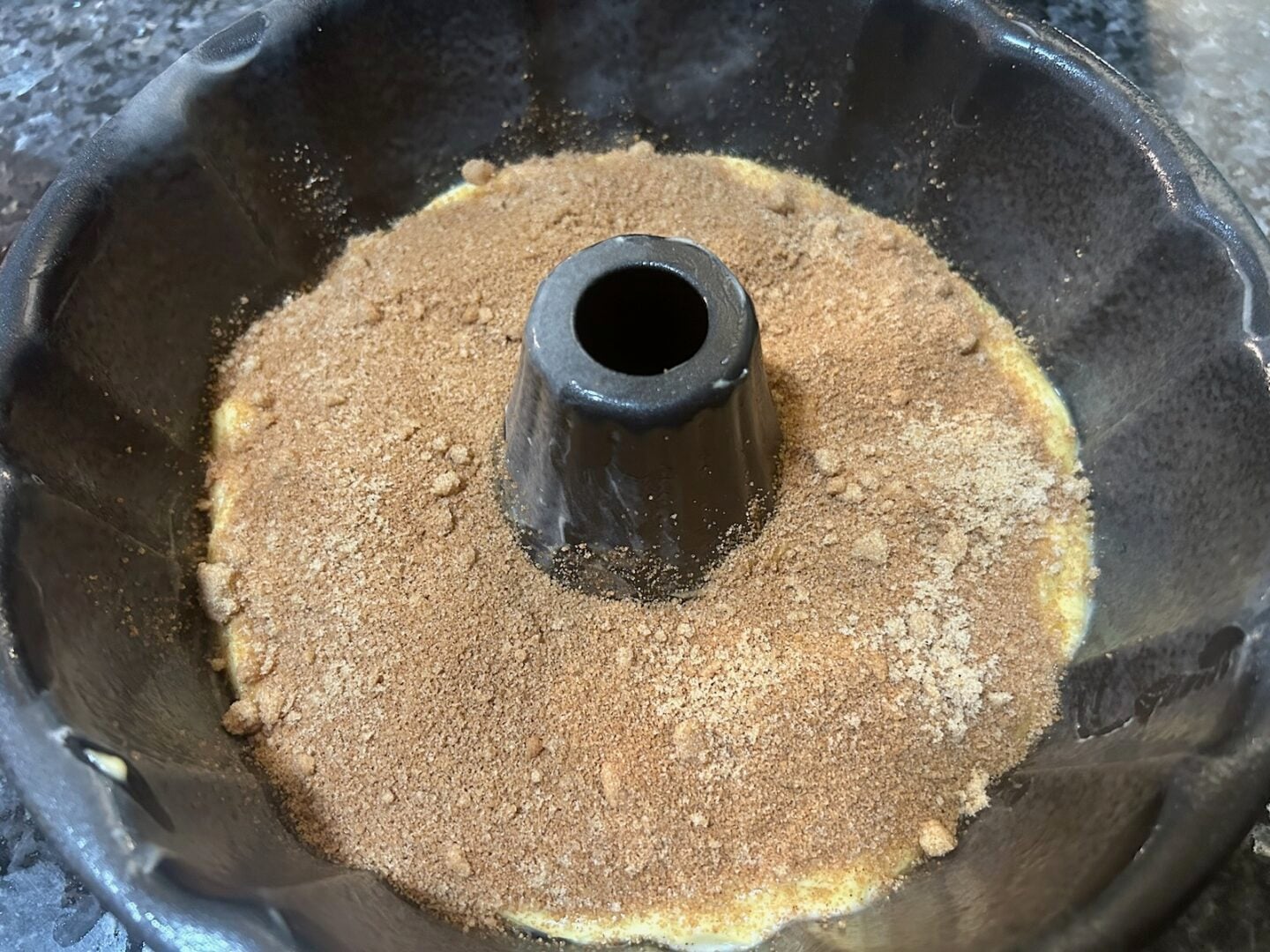 cinnamon topping on cake batter in bundt pan
