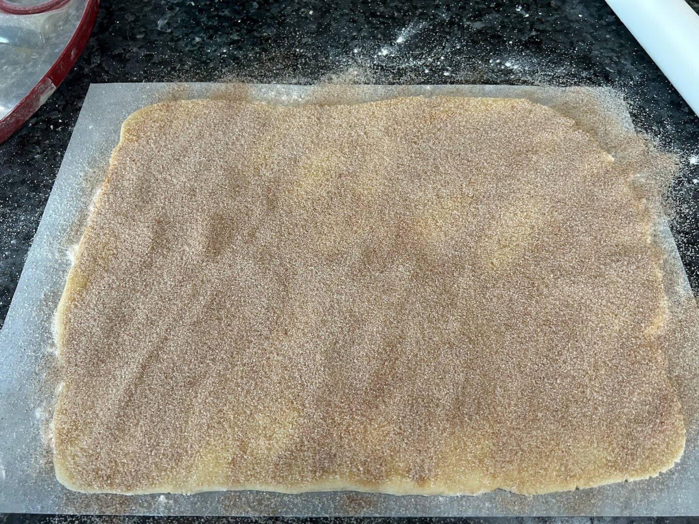 cookie dough rolled into rectangle with cinnamon sugar on top