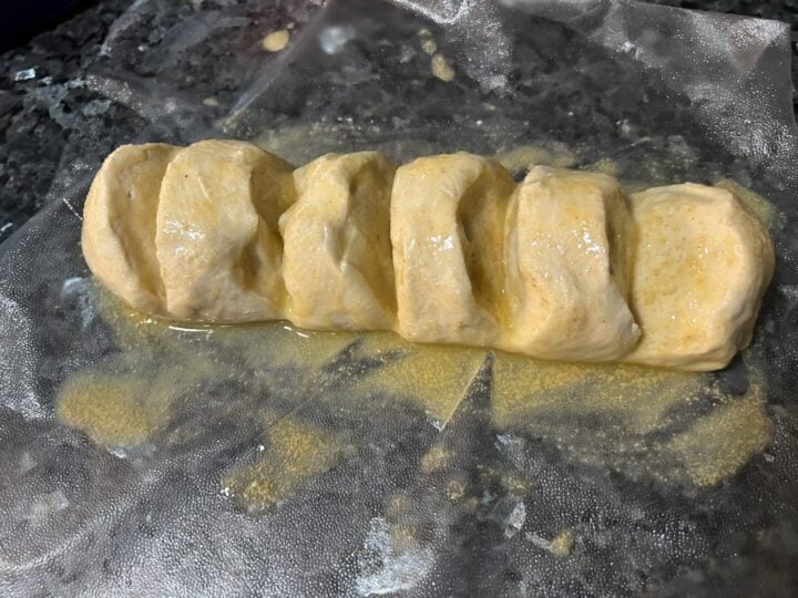 thawed loaf of dough with butter and garlic powder
