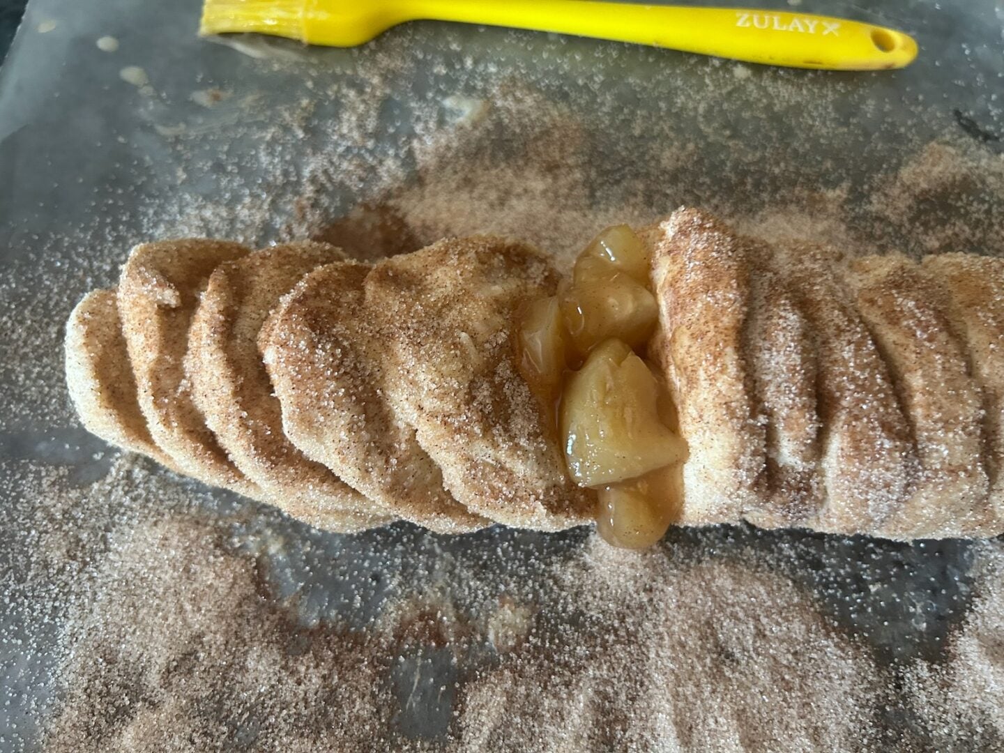 adding cinnamon sugar and caramel apples to bread loaf